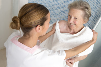 caregiver assisting a senior woman bathing