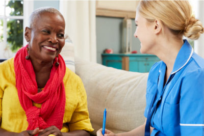 medication support assistance staff talking with the senior woman smiling