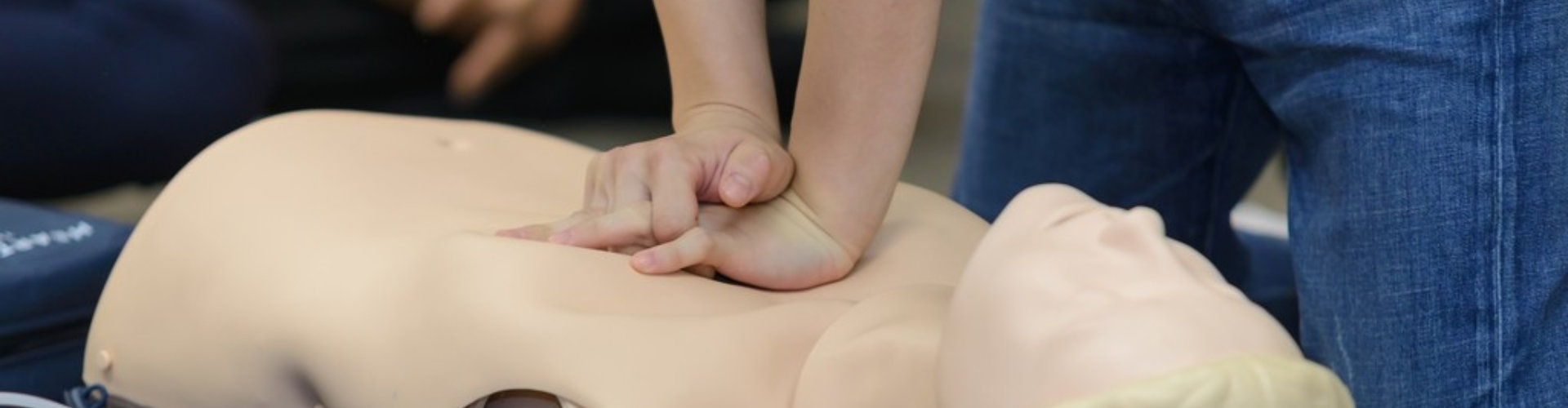 demonstrating chest compressions on cpr doll